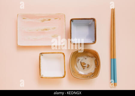 Empty plate and wooden chopsticks on pink background Stock Photo