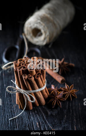 Cinnamon sticks bunch tied with rope on a dark background Stock Photo