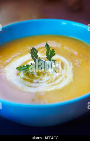 Close up of pumpkin soup in blue bowl Stock Photo