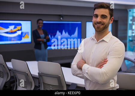 Portrait of male and female executives standing in boardroom Stock Photo