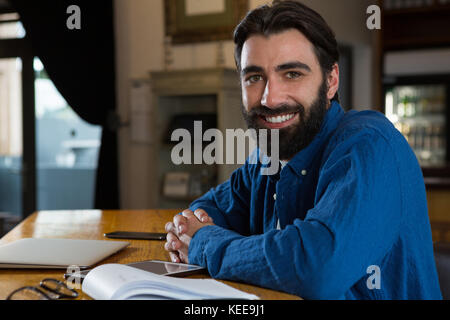 Portrait of happy bar tender leaning at bar counter Stock Photo