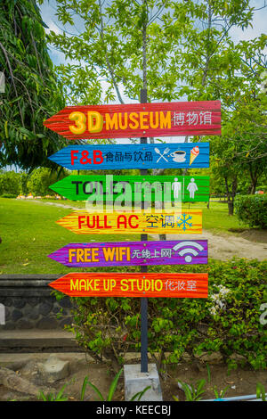 BALI, INDONESIA - MARCH 08, 2017: Informative sign in colorful arrows in a traditional balinese hindu temple Bajra Sandhi in Denpasar, Bali, Indonesia on background tropical nature and blue summer sky, Indonesia Stock Photo
