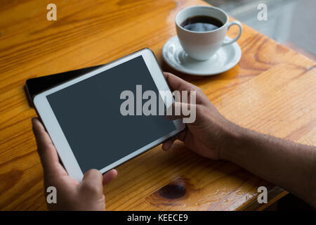 Mid-section of man using digital tablet in cafÃƒÂ© Stock Photo