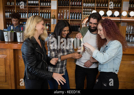 Happy friends having tequila shot at counter in bar Stock Photo