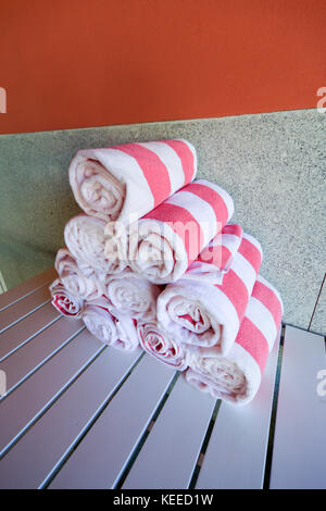 Pink & White striped pool towels rolled up in a pile Stock Photo