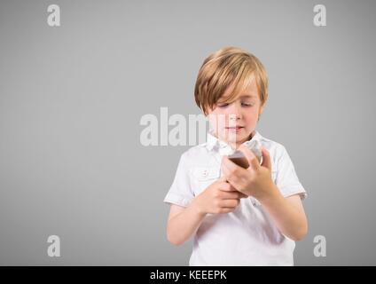 Digital composite of Boy against grey background with phone Stock Photo