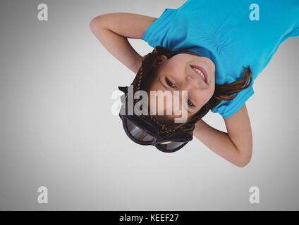 Digital composite of Girl against grey background with goggles upside down Stock Photo