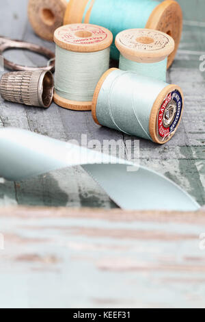 Vintage spools of thread with scissors, thimble and ribbon Stock Photo