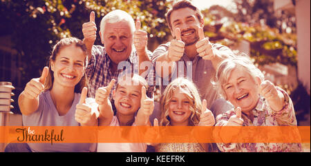 Thanksgiving greeting text against portrait of family gesturing thumbs up Stock Photo