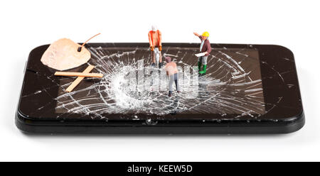 construction worker figurines repairing broken smartphone screen Stock Photo