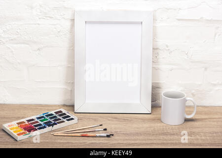 close up view of empty photo frame, coffee cup and drawing equipment on table Stock Photo