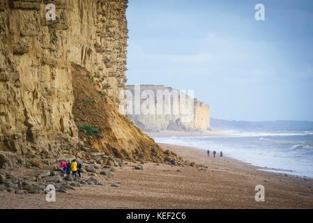 West Bay, Dorset, UK. 20th Oct 2017. UK Weather. People enjoying the relative calm before the storm predicted to hit the UK later today on a sunny but blustery day at the beach. Credit: Dan Tucker/Alamy Live News Stock Photo