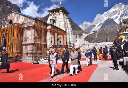 Kedarnath, India. 20th Oct, 2017. Indian Prime Minister Narendra Modi, center, walks alongside Gov. Trivendra Singh Rawat, right, as he visits the Kedarnath Temple shrine in the remote region of Uttarakhand October 20, 2017 in the Kedarnath, India. Credit: Planetpix/Alamy Live News Stock Photo