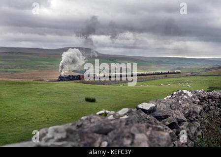 Ribblesdale, UK. 21st Oct, 2017. Steam special on the famous Settle - Carlisle railway line. Under a cloudy sky Jubilee class locomotive no. 45690 'Leander' hauls the Cumbrian Express up the steep climb to Ribblehead, at Selside, in the Yorkshire Dales National Park, 21st October. Pen-y-ghent peak in in the background. This is likely the last steam special on the line until 2018. Credit: John Bentley/Alamy Live News Stock Photo