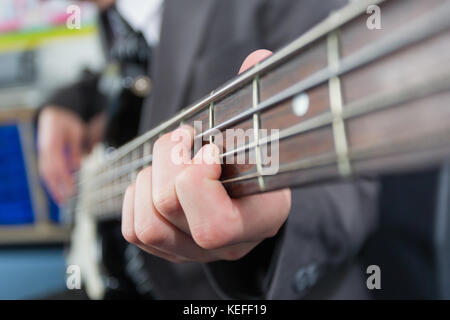 Pupil in a UK state school playing the bass guitar in music lesson Stock Photo