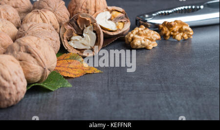 bio walnuts on a stone table with a nutcracker Stock Photo