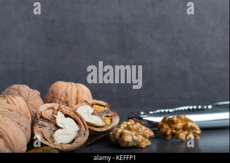bio walnuts on a stone table with a nutcracker Stock Photo