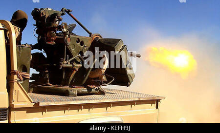 Still image taken from a propaganda video released October 18, 2017 showing Tahrir al-Sham in clashes against the Islamic State firing a heavy machine gun from the back of a pickup truck during battles east of Hama, Syria. HTS jihadists formed from former al-Nusra Front fighters have been fighting the Islamic State for control or the region. Stock Photo