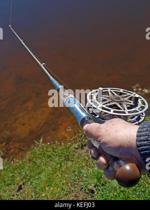 Hand holding angling rod, view close up Stock Photo