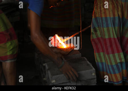 Workers in the steel re-rolling mills work without proper safety gear or tools. In these mills iron is forged in 1200 + to 1300+ Celsius. In such a he Stock Photo