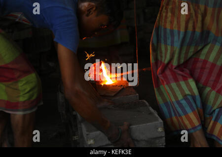 Workers in the steel re-rolling mills work without proper safety gear or tools. In these mills iron is forged in 1200 + to 1300+ Celsius. In such a he Stock Photo