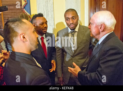 From left to right: American professional boxer and commentator Paulie Malignaggi;  American professional boxer and former WBA super welterweight champion Austin Trout; Phil Davis, former All American Wrestler & Bellator MMA fighter; and United States Senator John McCain (Republican of Arizona) share some thoughts following formal remarks at a press conference to discuss the observational study on the brain health of active and retired professional fighters on Capitol Hill in Washington, DC on Tuesday, April 26, 2016.  The study, led by researchers from the Cleveland Clinic, is  designed to be Stock Photo