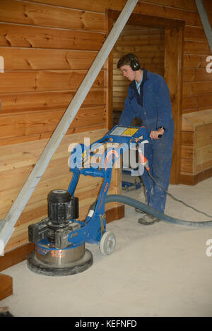 GREYMOUTH, NEW ZEALAND, JUNE 8, 2017: A tradesman polishes a concrete floor with a large grinder. Stock Photo