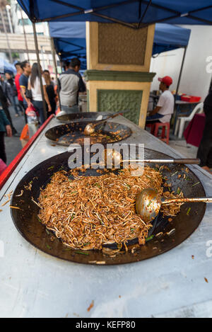 Cooked take away Flat noodles and bean sprouts in a sauce waiting in a large pan on a food vendors stall at a street food market in Asia. Stock Photo