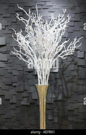 handmade artificial white a snowy branch in a pot on a dark background in the form of tiles Stock Photo
