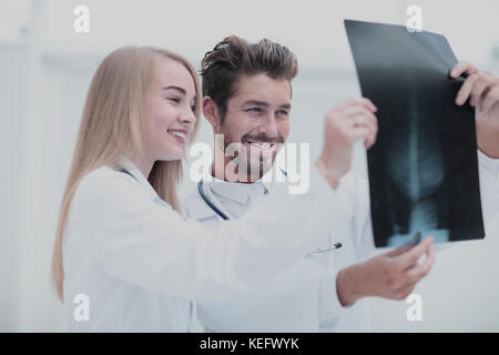 Closeup portrait of intellectual healthcare professionals with white labcoat, looking at full body x-ray radiographic image Stock Photo