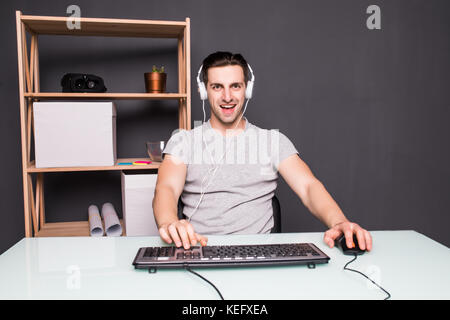 angry screaming young man in headset with pc computer playing game at home and streaming playthrough or walkthrough video Stock Photo