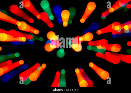 Multicolor defocussed bokeh Christmas lights against a black background with zoom effect Stock Photo
