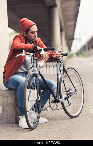handsome young man with vintage bicycle using smartphone Stock Photo