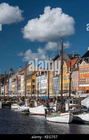 Nyhavn (New Harbour) is a 17th-century waterfront, canal and entertainment district in Copenhagen, Denmark,  It is lined by brightly coloured 17th and Stock Photo