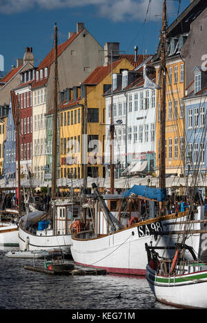 Nyhavn (New Harbour) is a 17th-century waterfront, canal and entertainment district in Copenhagen, Denmark,  It is lined by brightly coloured 17th and Stock Photo