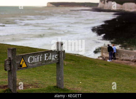 Warning sign near the chalk cliff edge of Birling Gap, East Sussex, UK Stock Photo