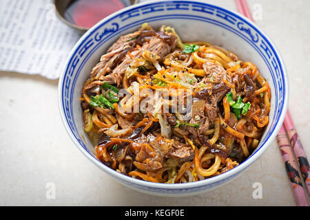 Hoisin duck noodles. Egg noodles with strips slow roasted duck in hoisin sauce with oak choi. Stock Photo