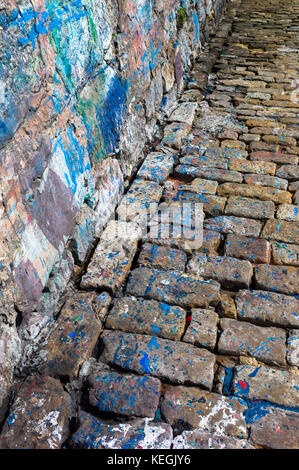 Abstract paint colour splashes where boats painted by sea wall in harbour of Castro Urdiales, Cantabria, Spain