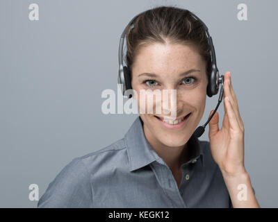 Smiling beautiful woman with headset: call center and customer support operator Stock Photo