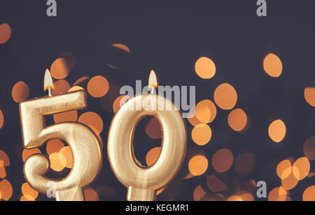 Gold number 50 celebration candle against blurred light background Stock Photo