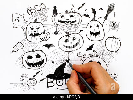 Person hand with black pen drawing Halloween concept. Stock Photo