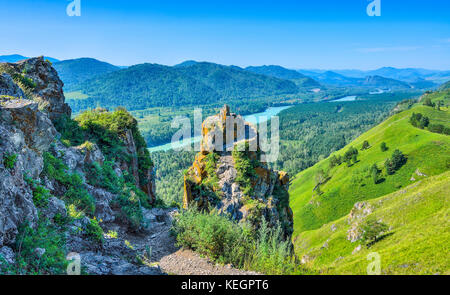 Cliffs over the swift mountain turquoise river Katun, flowing in the valley among the banks with dense forests covered - beautiful sunny summer landsc Stock Photo