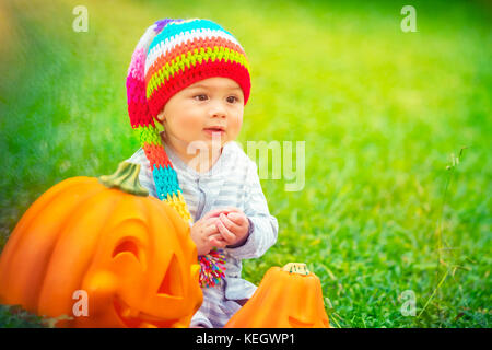 Portrait of a pretty child celebrating Halloween holiday, traditional American holiday with traditional pumpkins with carved smiling faces, happy time Stock Photo