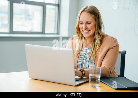 Businesswoman using laptop in conference room Stock Photo