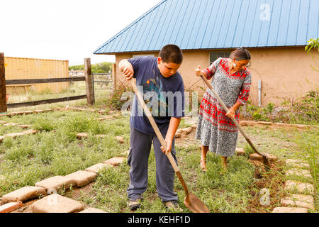 Mother and son shoveling in garden Stock Photo