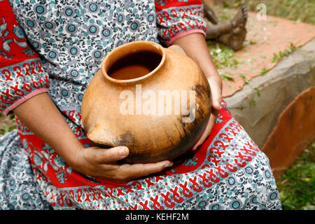 Woman sitting and holding clay pot Stock Photo