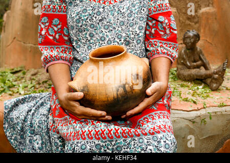 Woman sitting and holding clay pot Stock Photo