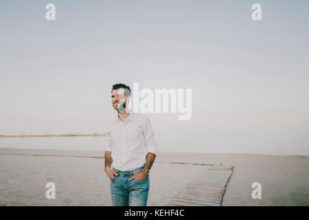 Caucasian man standing on beach Stock Photo