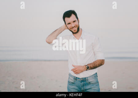 Caucasian man standing on beach Stock Photo