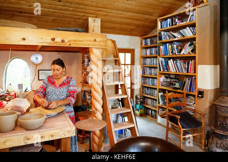 Mixed race woman shaping clay in art studio Stock Photo
